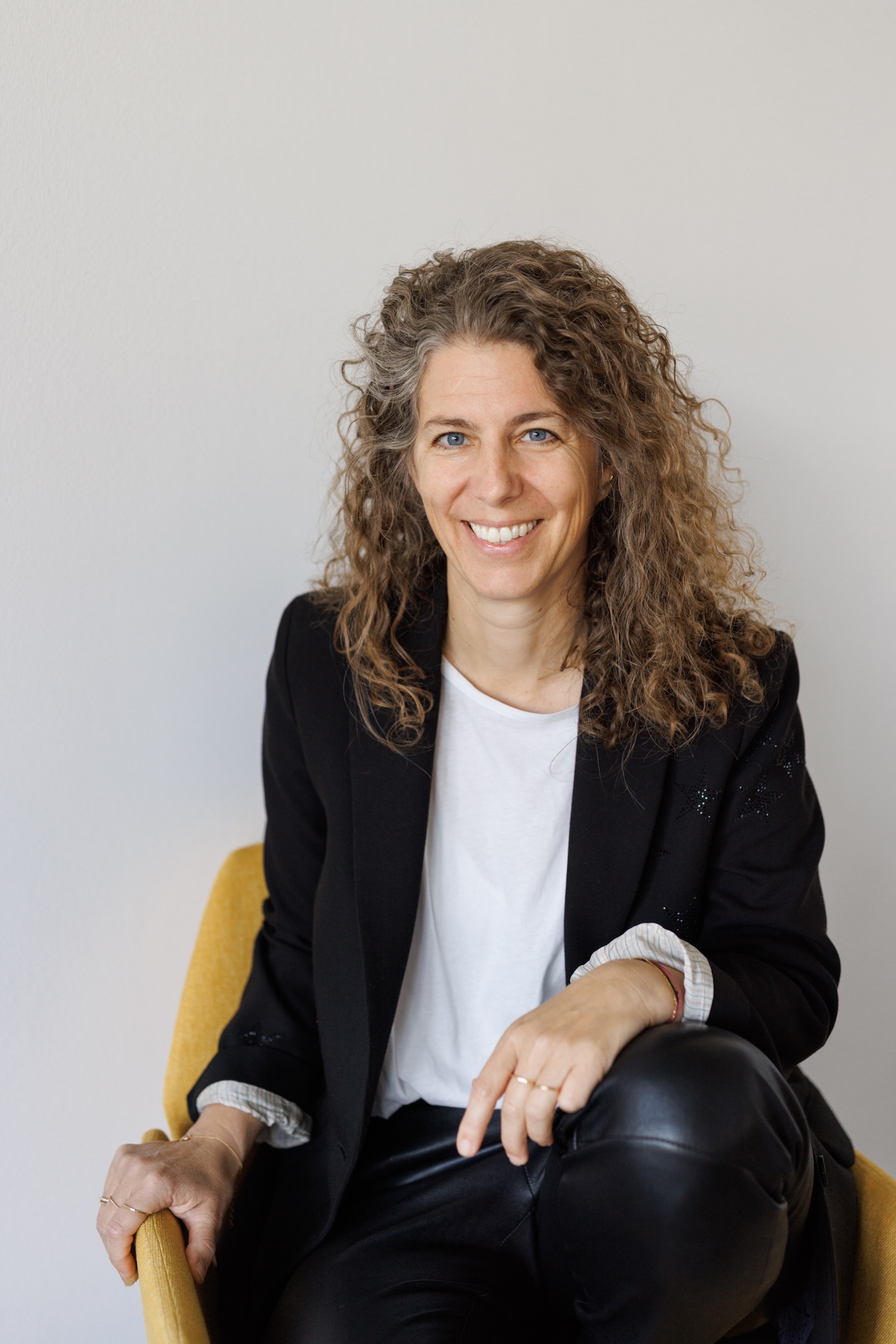 Agnes Goldmann sitzt in einem Sessel und sieht in die Kamera